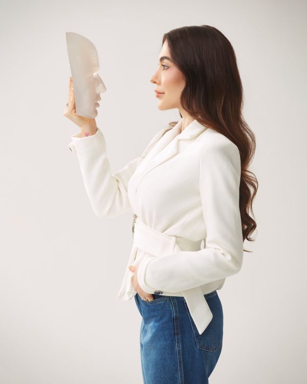 Dra. Katarina Bessa de perfil, observando uma máscara facial translúcida